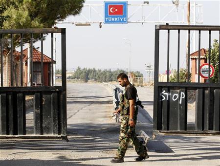 A Free Syrian Army soldier mans the last gate before the Turkish territory at the Bab Al-Salam border crossing