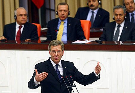 Germany's President Christian Wulff addresses the Turkish parliament in Ankara on October 19, 2010, as Turkey's Prime Minister Tayyip Erdogan (2nd R) and his ministers listen. Germany's president urged Turks and Germans Tuesday to see they "are closely connected" as he sought to ease a simmering debate on whether Berlin had failed in efforts to integrate Muslim immigrants. AFP PHOTO / ADEM ALTAN