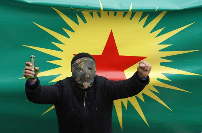 A masked demonstrator poses with a banner for the outlawed PKK during protests in Istanbul in April [Reuters]