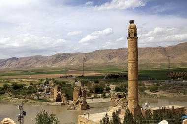 A minaret juts upward from the El Rizk mosque, built in 1409 (foreground, r.) near the remains of a medieval bridge that crosses the Tigris River. When the proposed dam is filled, only about the top 12 feet of the minaret will be above water.  Jonathan Lewis