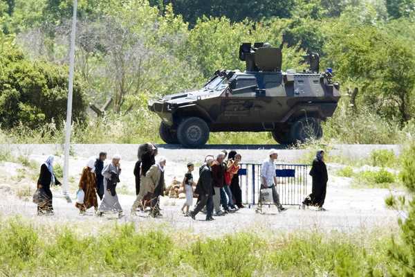 Syrian refugees pass a Turkish military vehicle as they cross the border near the Turkish village of Guvecci in Hatay province. Syrian activists say Syrian troops backed by tanks and snipers have entered a village along the border. (Burhan Ozbilici, Associated Press / June 24, 2011)