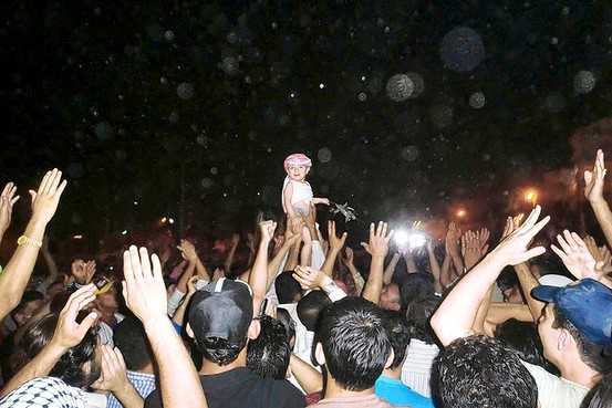 Protesters hold a child up during a demonstration against President Bashar al-Assad in Deir el-Zour, Syria, on Thursday.