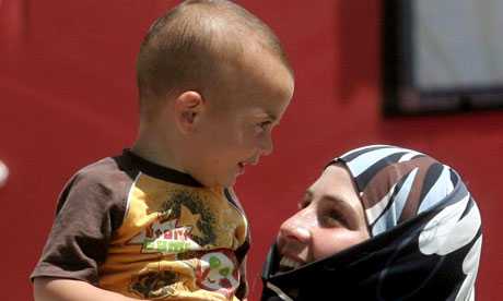 A Syrian refugee and child in Turkey. Protesters in Britain have claimed that agents of the Assad regime have threatened them and their families in Syria. Photograph: Adem Altan/AFP/Getty