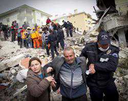 Relatives of an earthquake victim are led away from ruins by a Policeman on October 25 2011 in Van Turkey Credit Ahmad Halabisaz Getty Images News Getty Images CNA World Catholic News 10 26 11