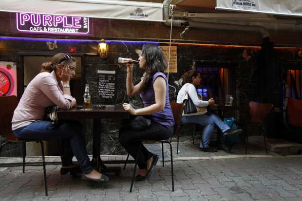 Patrons sit outside a bar in Beyoglu, in the heart of Istanbul, where authorities have banned tables and chairs in the street since mid-July.  Charla Jones for The Globe and Mail