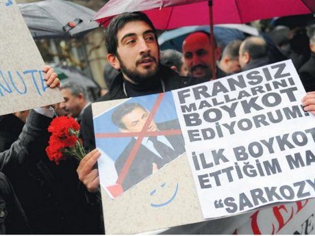 A man holds a placard reading "I boycott French goods" during a demonstration in front of the French consulate in Istanbul to protest a new law in France outlawing denial of the 1915 Armenian genocide in Ottoman Turkey.