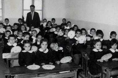 Cin Ali, the squiggly stick figure in a cap whose benign adventures in big-print, picture books helped a generation of Turks learn to read in primary school. In this undated photo, teacher Rasim Kaygusuz, creator of Cin Ali, stands with his primary school students.  File/Kaygusuz Family/AP