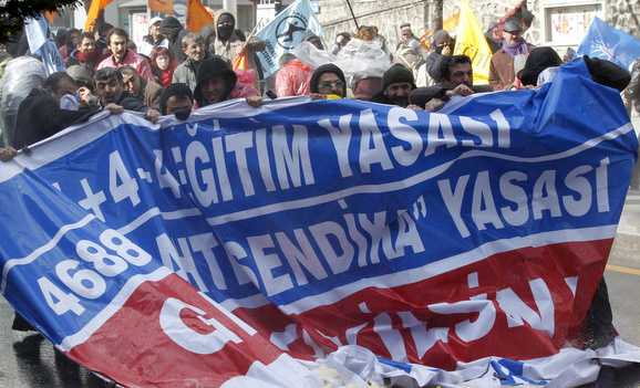 Demonstrators hold a banner as police use a water cannon and tear gas to disperse them during a protest in Ankara