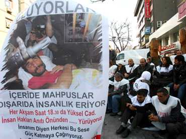 Members of a pro-Kurdish party stand behind a banner reading "They are dying" as they start on November 17, 2012 a two-day hunger strike in support of the several hundreds Kurdish inmates who have been on hunger strike for 67 days in Ankara. (AFP Photo / Adem Altan)