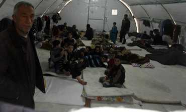 Syrian refugees are seen through the window of a tent as they rest in a refugee camp in the town of Nizip in Gaziantep province