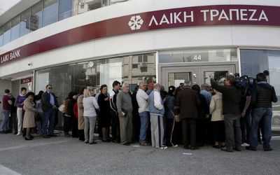 Customers queue up outside a branch of Laiki Bank as they wait for the reopening of the bank in Nicosia. Picture: REUTERS