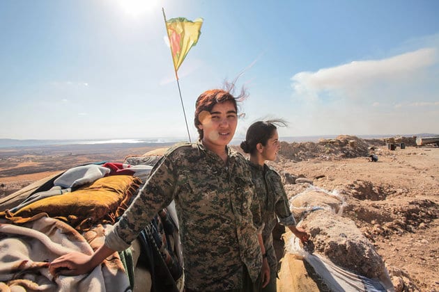 KOBANE, SYRIA - JUNE 20: (TURKEY OUT) A Kurdish People's Protection Units, or YPG women fighters pose as they stand near a check point in the outskirts of the destroyed Syrian town of Kobane, also known as Ain al-Arab, Syria. June 20, 2015. Kurdish fighters with the YPG took full control of Kobane and strategic city of Tal Abyad, dealing a major blow to the Islamic State group's ability to wage war in Syria. Mopping up operations have started to make the town safe for the return of residents from Turkey, after more than a year of Islamic State militants holding control of the town. (Photo by Ahmet Sik/Getty Images)