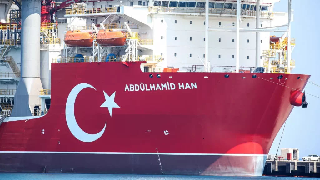 Abdülhamit Han Gemisi Güney Kore’de ABD li bir firma için 2013 de Cobalt Explorer adıyla inşa edilmeye başlanmıştı. Daha sonra Mayıs 2019'da uluslararası Northern Drilling adlı şirket gemiyi satın aldı ve geminin adını West Cobalt olarak değiştirdi ancak bu sözleşme de Ekim 2019'da sonlandırıldı.Gemi, Kasım 2021'de TPAO tarafından Daewoo'dan 180 milyon Amerikan doları karşılığı satın alındı ve adı da Abdülhamit Han olarak değiştirilerek Türkiye’ye getirildi.7 nci nesil ve son teknolojiyle donatılmış olan Abdülhamit Han sondaj gemimiz dünyadaki en gelişmiş 5 sondaj gemisinden birisi olup 12bin 200 metreye kadar sondaj yapabilme yeteneğine sahiptir.Gemi alındığı günden beri göreve çıkacağı 9 Ağustos’u ve görev yerini heyecanla bekledik.Cumhurbaşkanı Recep Tayyip Erdoğan, "Akdeniz'de yaptığımız arama ve sondaj çalışmaları kendi egemenlik alanlarımızdadır. Bunun için kimseden izin veya icazet almaya ihtiyacımız yoktur." Diyerek konuşmaya başlayınca bekledik ki Libya ile yapılan MEB (Münhasır Ekonomik Bölge) Anlaşmasını ve özellikle de Yunanistan’ın Meis adasının MEB si olmadığını da dünyaya göstermeye yönelik bir görev yeri seçilecek. Maalesef görev yerinin Gazipaşa'nın 55 kilometre açığındaki Yörükler-1 kuyusu olarak açıklanması konulara hakim Mavi Vatan savunucuları bizler için hayal kırklığı olmuştur. Kıyılarımızdan 55 km. açığı zaten bizim Kıta sahanlığımız içindedir. Libya ile yapılan MEB anlaşması ile Meis adasının uluslar arası hukuka aykırı olarak iddia edilen MEB hakkının olmadığını dünyaya gösterecek şekilde kıyıdan Libya yönüne doğru 200-250 km açıkta bir bölgede görevlendirilmesi gerekirdi.Uluslar arası hukuka göre ülkelerin hava sahası kara suları sınırı kadardır. Yunanistan 6 millik karasuları üstünden başlaması gereken hava sahası sınırının kendince 10 mile çıkarmış Türkiye bunu kabul etmemiş, etmeyecektir de . Ancak bu kabul etmemek sözlü ifade ile yeterli olamazdı eylemle de ortaya konulmalıydı. Nitekim öyle de oldu Türk Hava Kuvvetleri dün de bugün de Yunanistan’ın 10 mil iddia ettiği bölgelerde eğitim uçuşları yaparak bunu fiilen ortaya koymaktadır. Eğer bu tepkiler gösterilmeseydi bölgede uçuşlar yapılmasaydı dolaylı olarak Yunanistan’ın hava sahası 10 mil kabullenilmiş olacaktı. Aynı durum Yunan adalarının özellikle de Meis’in uluslar arası hukuka aykırı olarak MEB iddiası için de söz konudur. Bu oldu bittiyi kabullenmemek ve Libya ile yapılan MEB anlaşmasının güdük kalmaması için Abdülhamit Han Gemimizin özellikle de Yunanistan’ın Meis adası için iddia ettiği MEB sahasında sondajlar yapması önem arz etmektedirÖte yandan Jeoloji ve Jeofizik uzmanı Prof. Dr. Doğan Perinçek’in ( geçmişte Türkiye Petrollerinde de çalışmış) açıklamaların göre de Yörükler-1 de petrol bulma şansı çok düşük.Özetlersek Cumhurbaşkanı etrafındaki Amerikancı ekip yine yapacağını yapmış ve Abdülhamit Han Gemisine suya sabuna dokunmayan adıyla ve cüssesiyle hiç uymayan bir görev verilmiştir.İhsan Sefa (E.Hv.Kur.Alb) - abdulhamid han sondaj gemisi